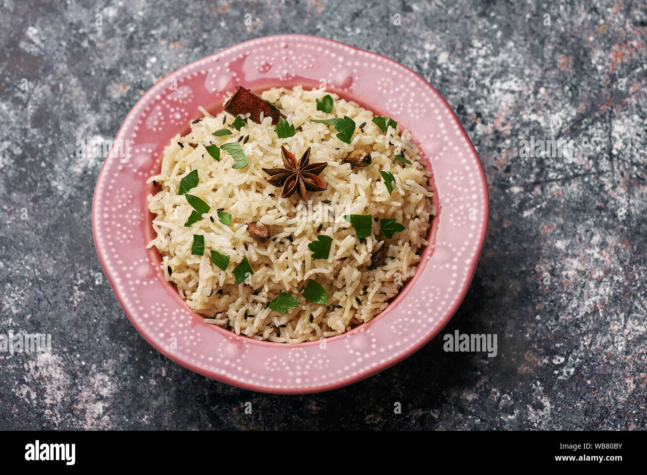 Jeera Rice in pink plate at dark bacgkround. Jeera rice traditional
