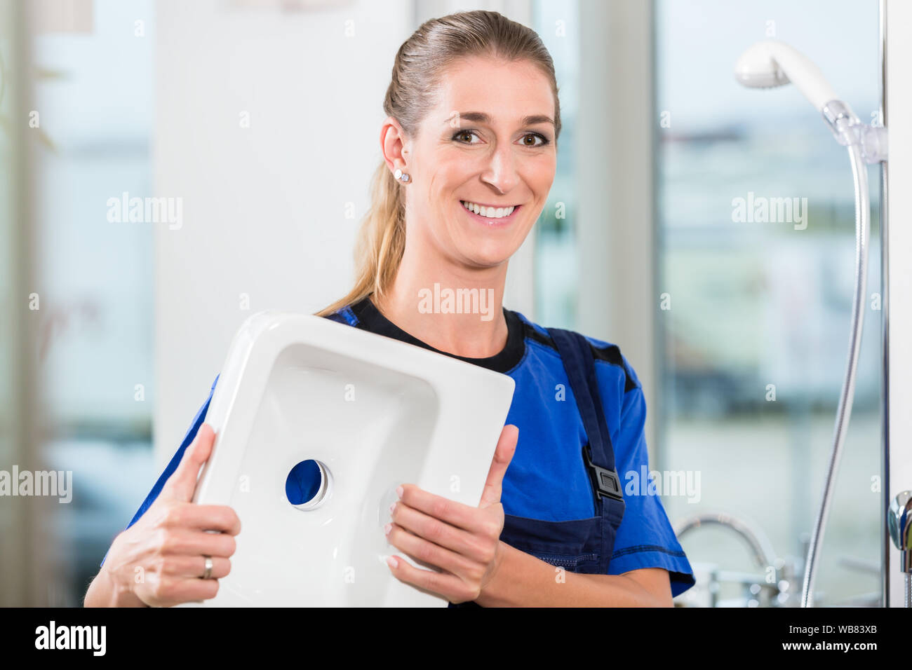 Female worker at work in a sanitary shop with high-quality ceramic fixtures Stock Photo