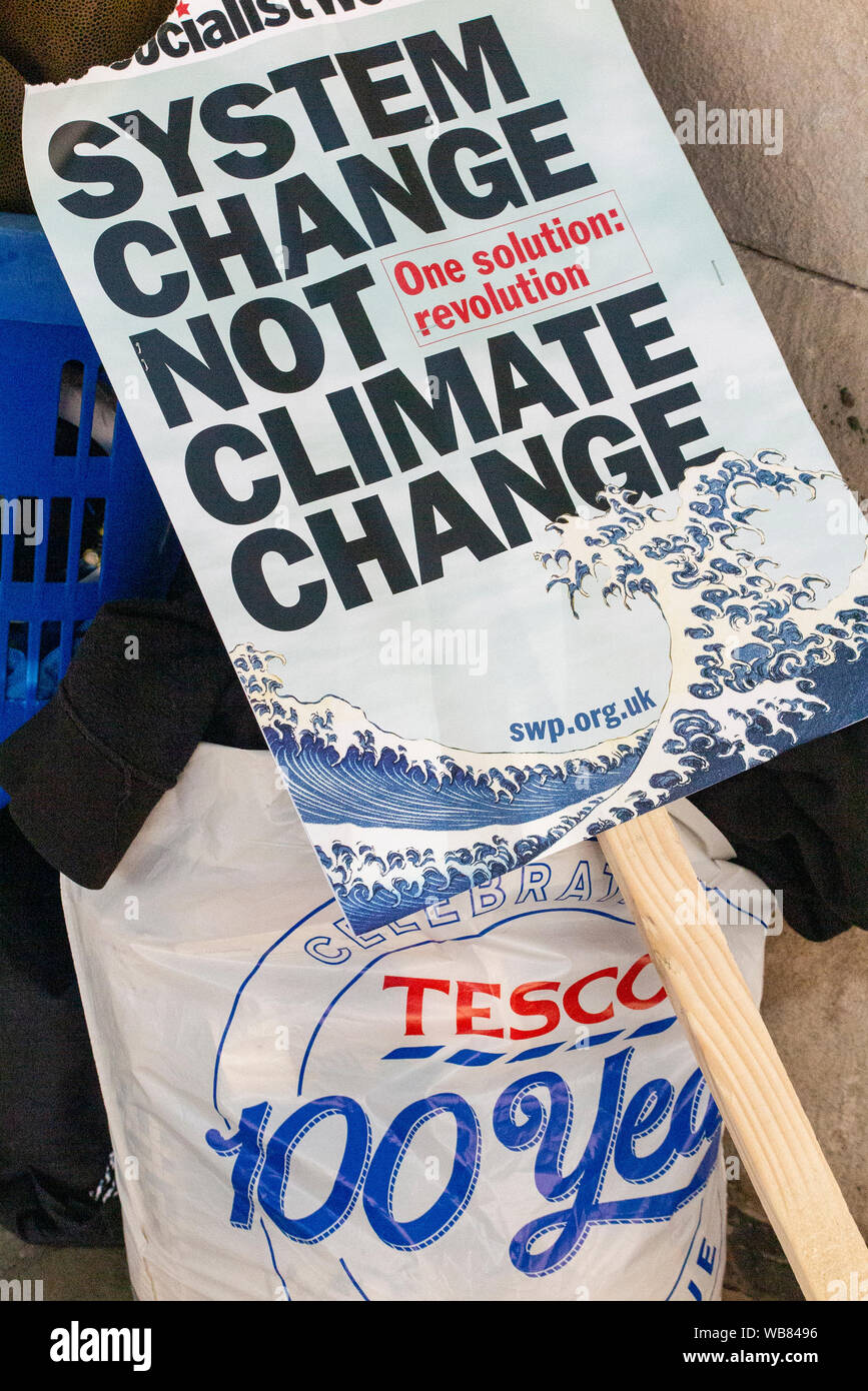 London, England, UK 23rd August 2019. An ironic contrast - a Tesco plastic bag next to a demonstrator's Climate Change placard Stock Photo
