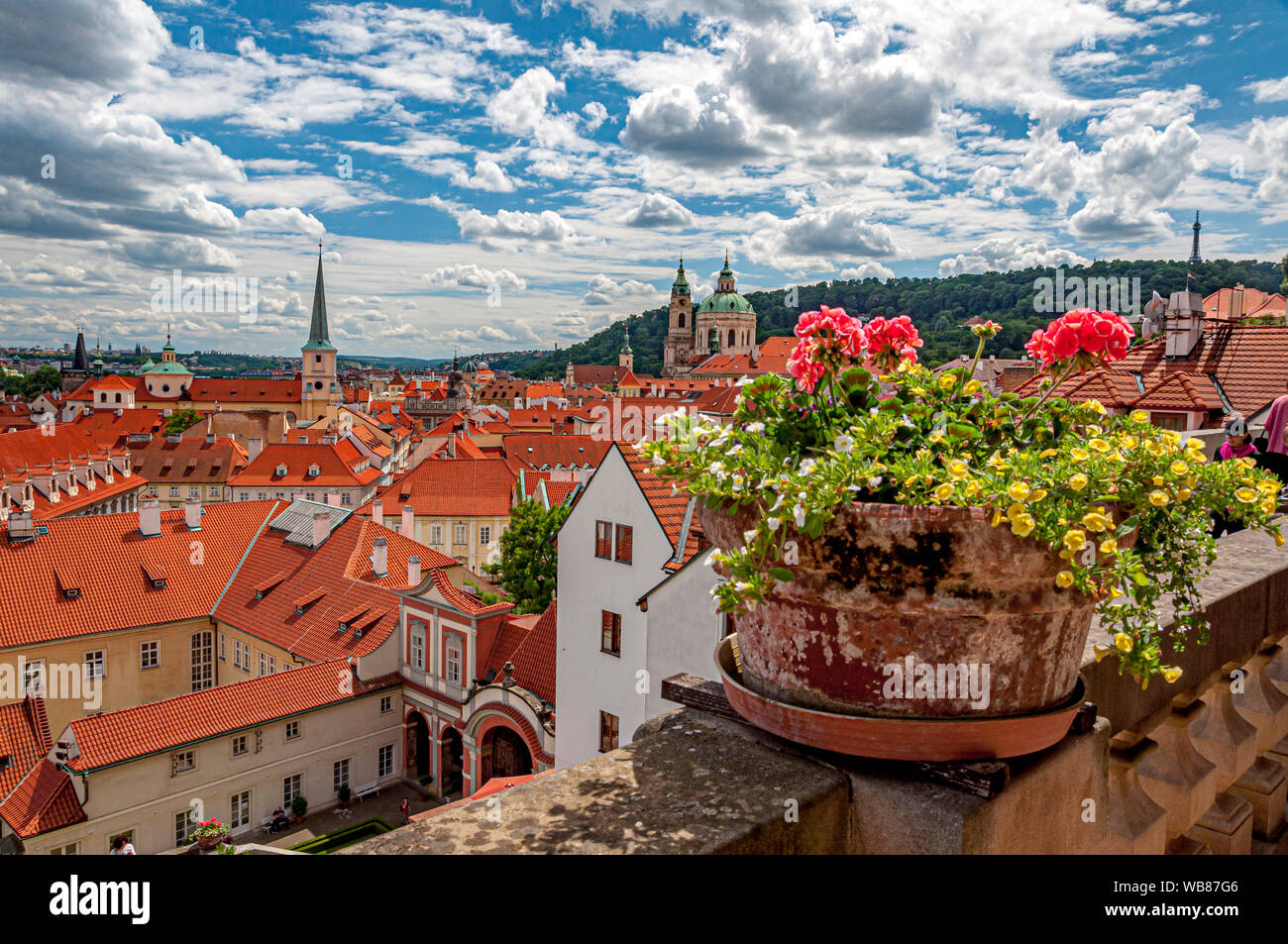Prague: View overlooking the red rooftops of the Lesser Town (Malá Strana) from the Old Royal Steps leading to Prague Castle, with the city lights beginning to twinkle at dusk.
