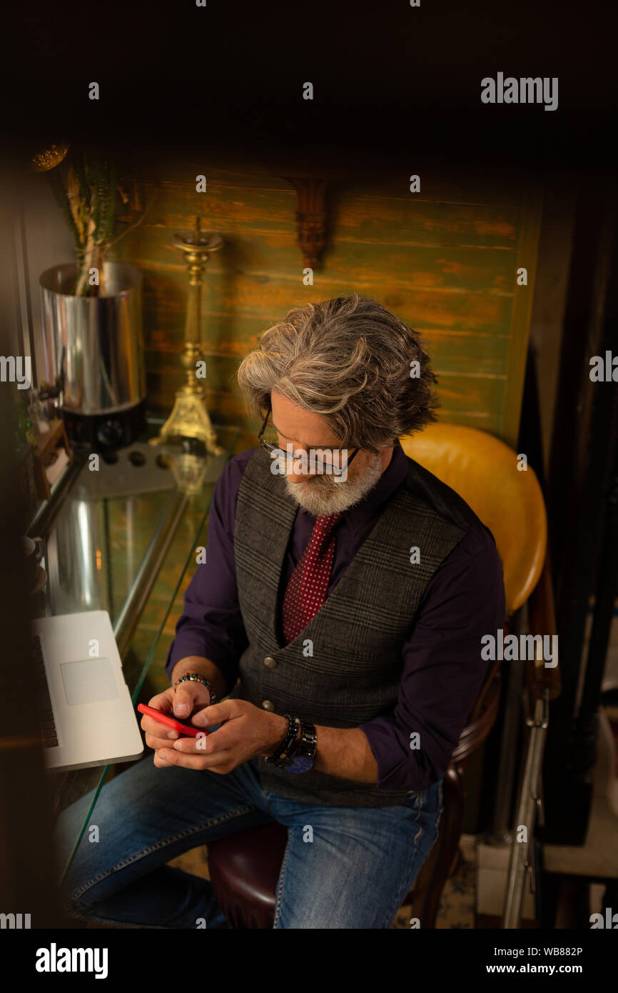 Concentrated man writing messages to his colleagues. Stock Photo