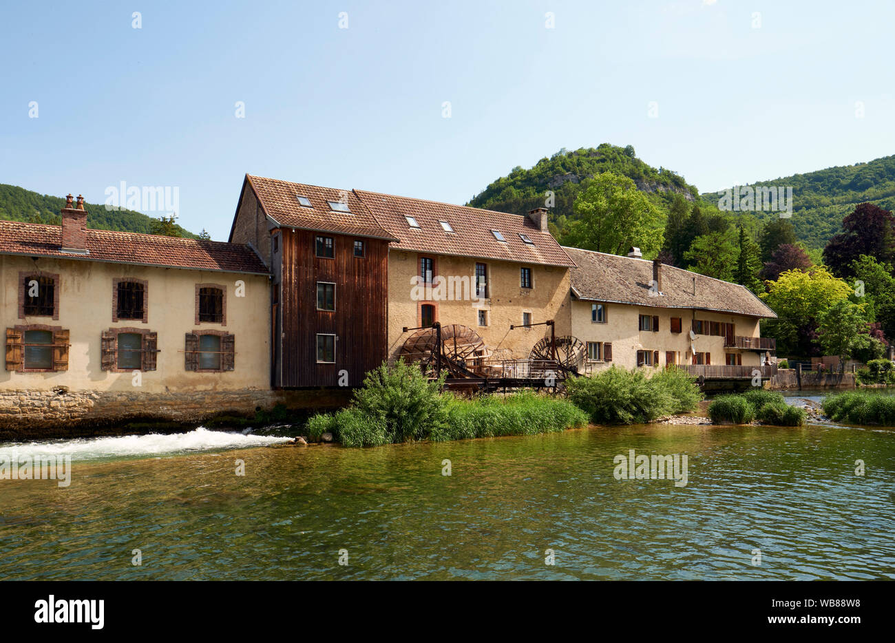 Vuillafans and the river Loue with a watermill in the Doubs department in the Bourgogne-Franche-Comté region in eastern France. Stock Photo