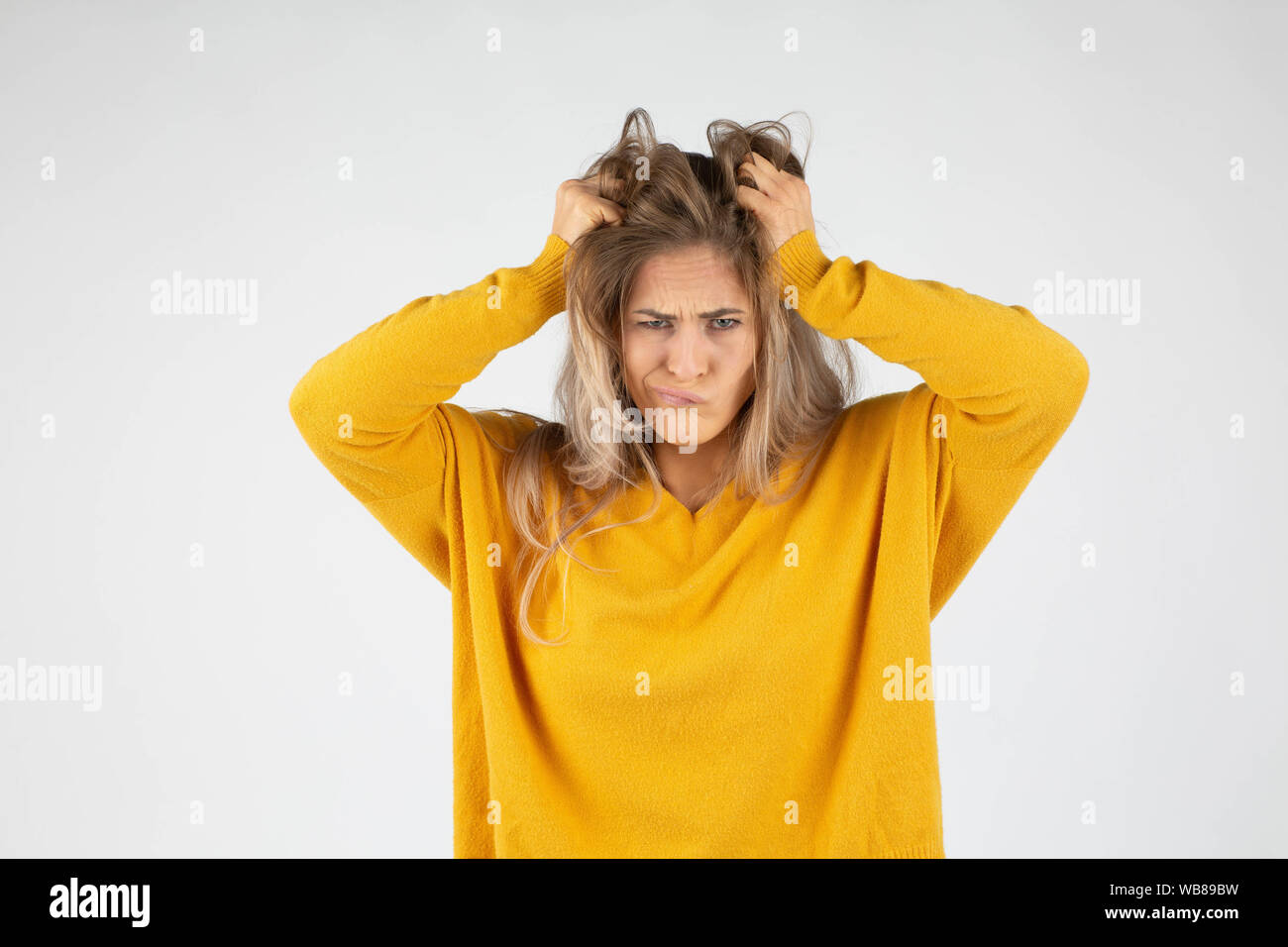 blond angry woman tearing her hair because anger and stress Stock Photo