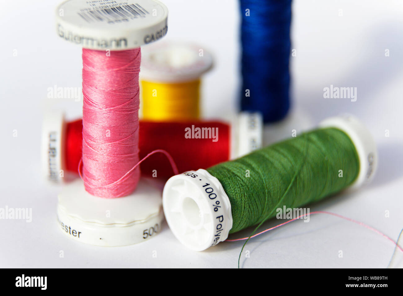 Umea, Sweden - August 15, 2019: sewing thread on reel in different colors on white background Stock Photo
