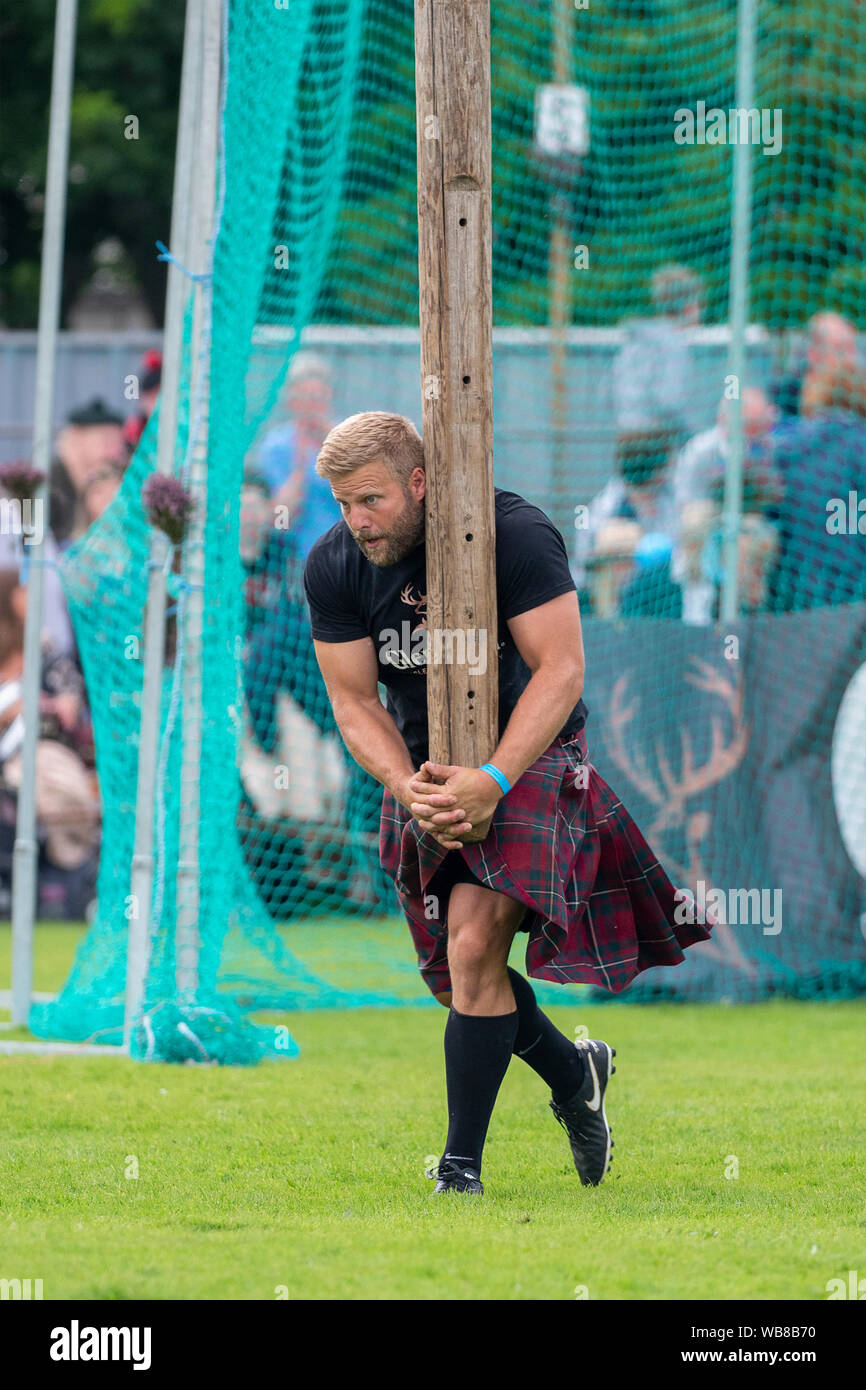 Lonach Gathering, Scotland - Aug 24, 2019: Tossing the Caber event at the Lonach Gathering in Scotland. Stock Photo