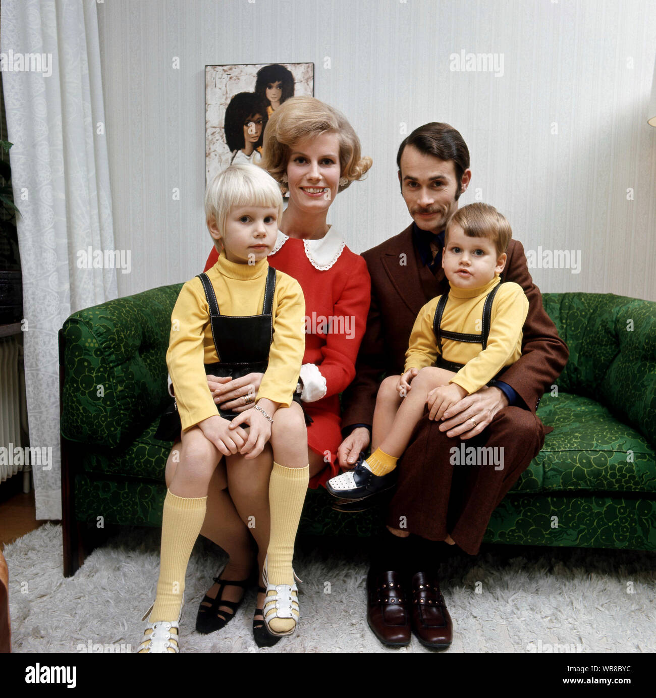 1960s parents. A mother and father are sitting together with their children in a green sofa. Sweden 1969 Stock Photo