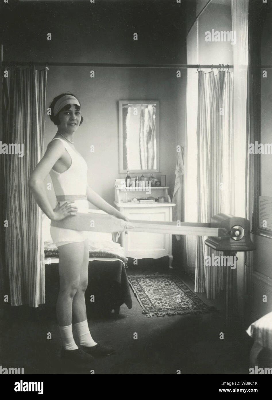 Massage in the 1930s. The swedish actress Disa Gillis demonstrates the belt massager and exercise machine that is designed to vibrate and massage the body. Sweden 1930s Stock Photo