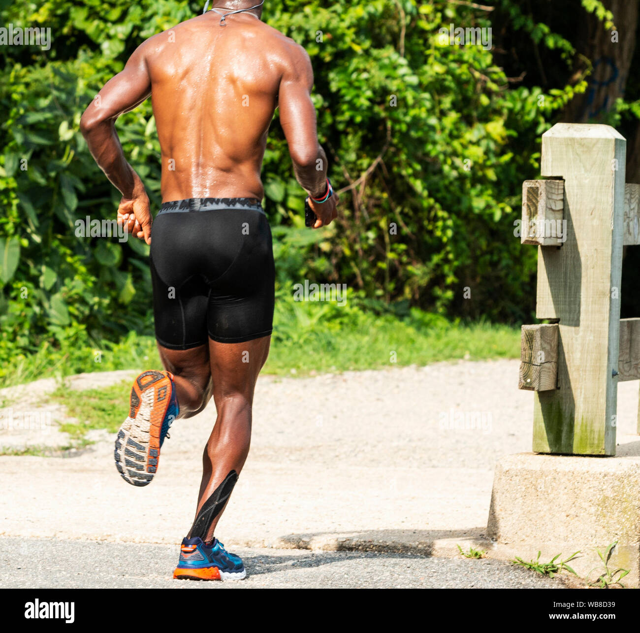 An African American man is running with no shirt on and seating in the