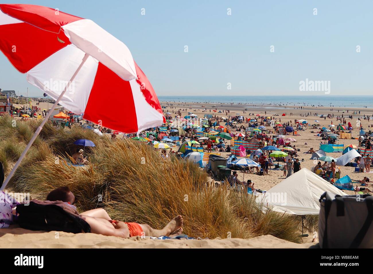 Camber, East Sussex, UK. 25 Aug, 2019. UK Weather: The hot sunshine beats down on these sunbathers on a very busy Bank Holiday Weekend at the Camber Sands beach in East Sussex. ©Paul Lawrenson 2019, Photo Credit: Paul Lawrenson/Alamy Live News Stock Photo