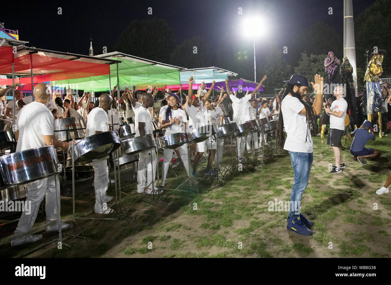 Conductor Andre White and steel pan players of Mangrove address the audience at the end of their performance at Panorama. Stock Photo