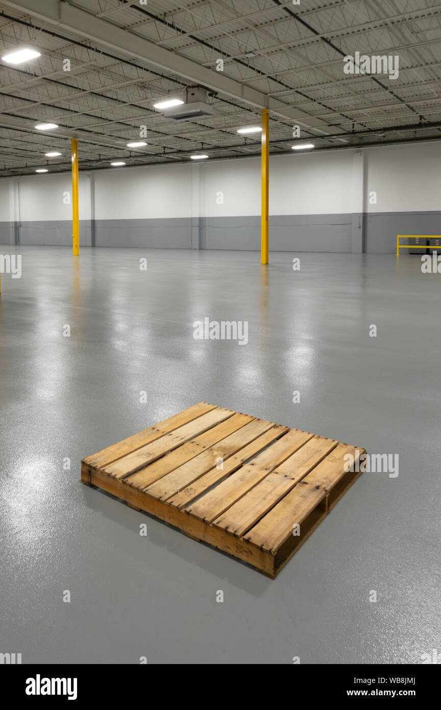 Empty Pallet In Large Warehouse, USA Stock Photo