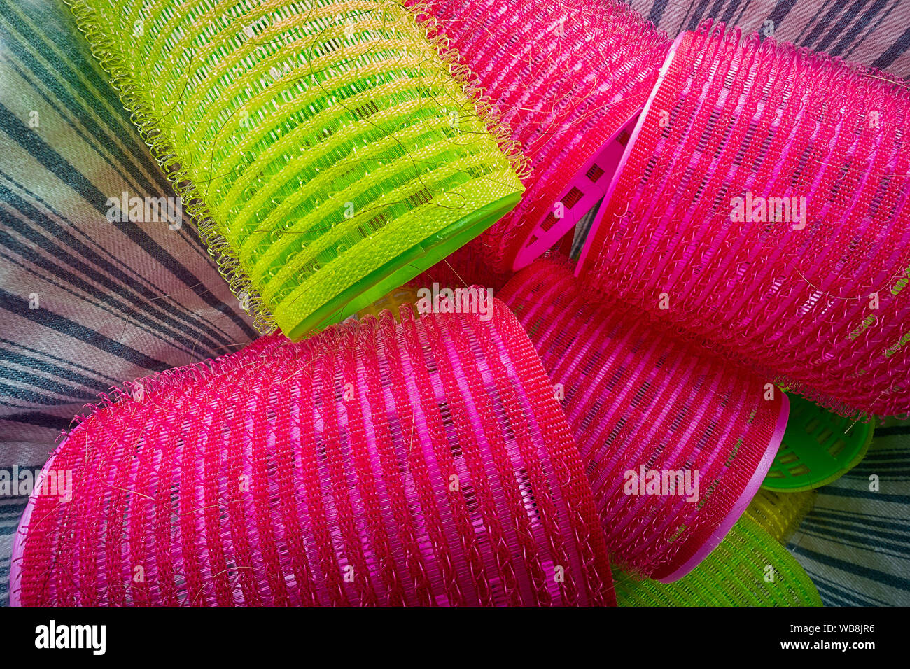 Pile of colorful hair curlers in basket Stock Photo