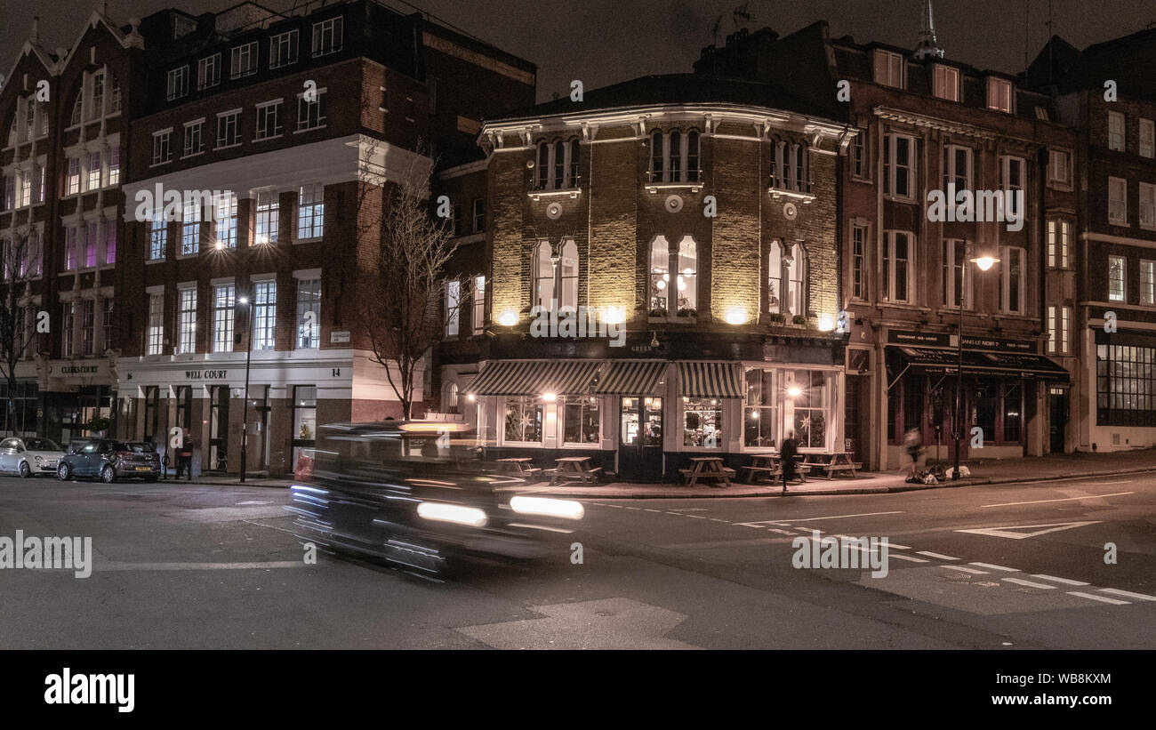 London pub at night. passing cab. London streets Stock Photo