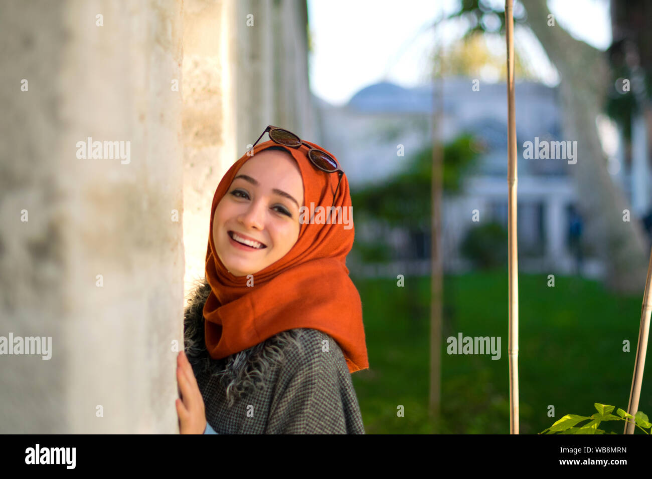 Muslim girl laughing and leaning on the wall Stock Photo - Alamy