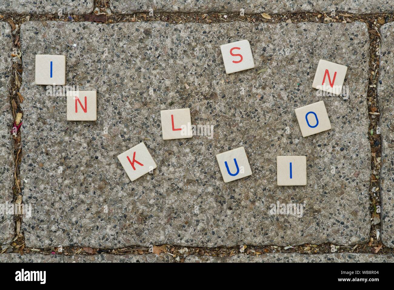 INKLUSION (inclusion) as wooden letters on a brick Stock Photo