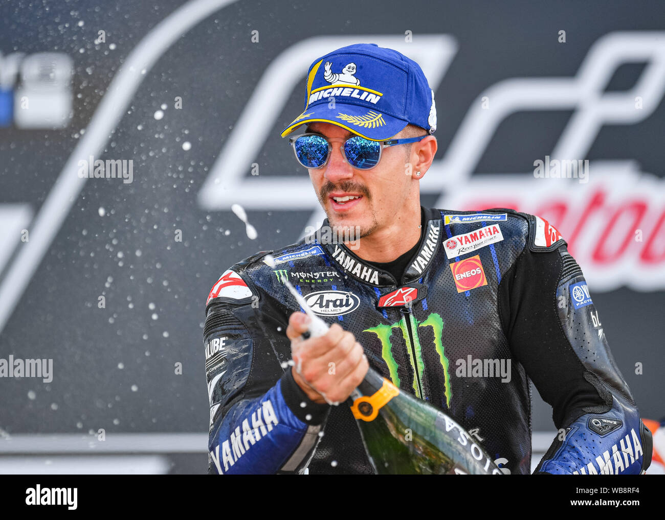 Towcester, UK. 25th Aug, 2019. Maverick Vi?ales (SPA) of Monster Energy Yamaha MotoGP celebrates with the Champagne after the Sunday Race at Winner’s presentation after the Sunday’s Race of  GoPro British Grand Prix at Silverstone Circuit on Sunday, August 25, 2019 in TOWCESTER, ENGLAND. Credit: Taka G Wu/Alamy Live News Stock Photo