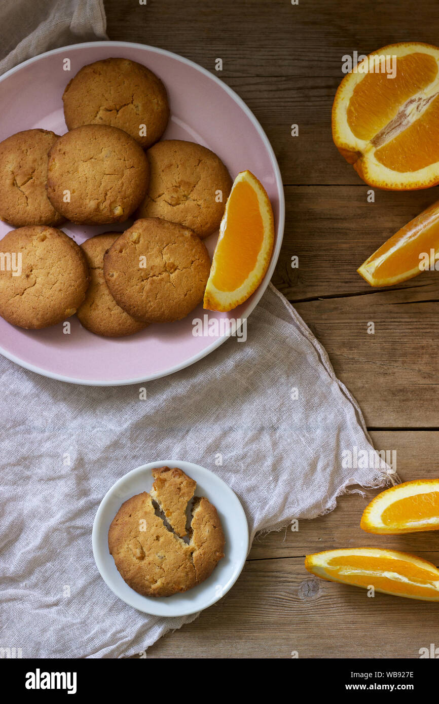 Crispy cookies with candied orange and sliced orange on a wooden surface. Rustic style. Stock Photo