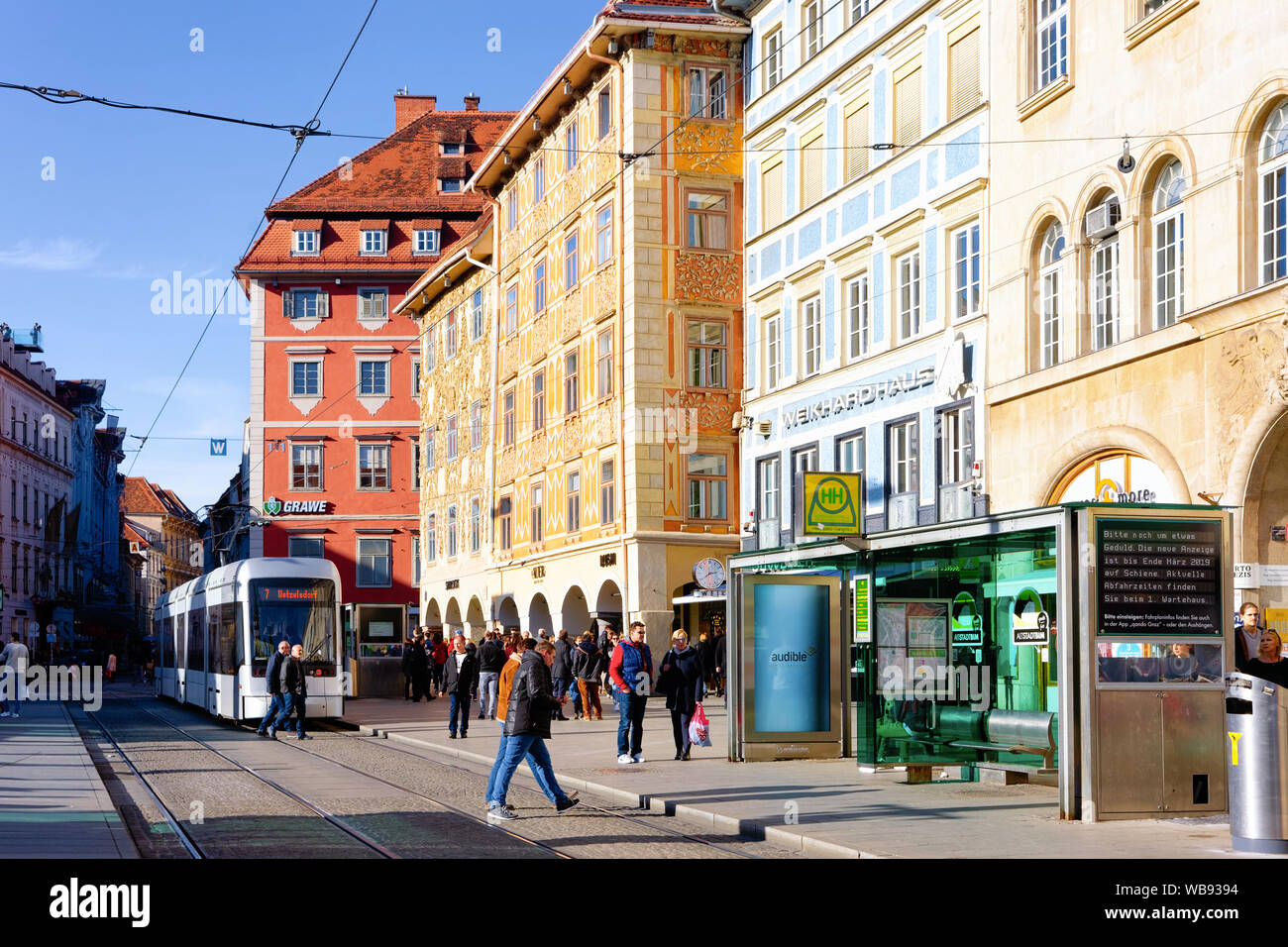 Graz, Austria - February 16, 2019: Tram and people at bus stop on  Herrengasse Street in Downtown