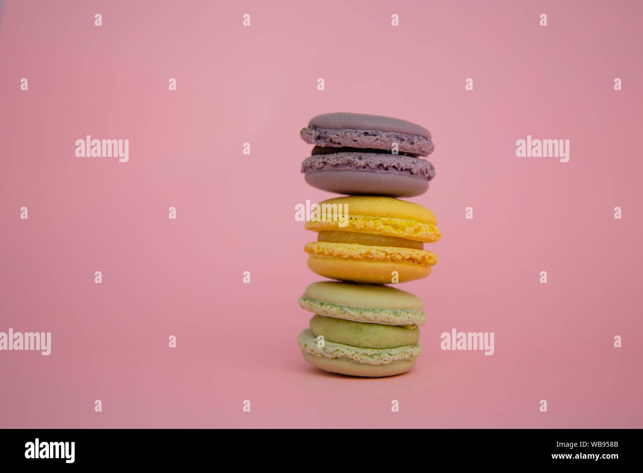 Three French macaroons stacked on top of each other with pink ...