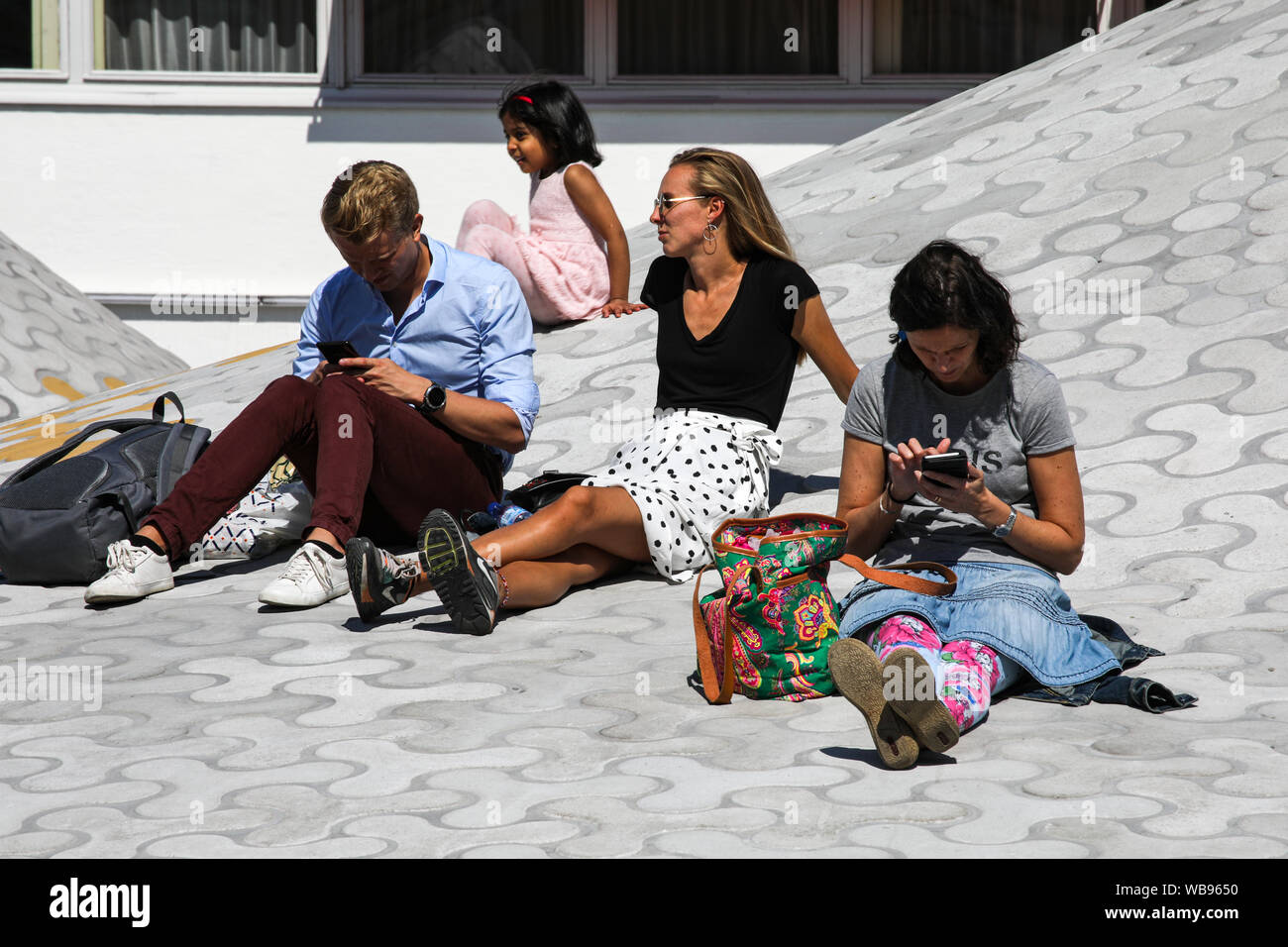 People relaxing on dome of Amos Rex art museum, built under Lasipalatsi Plaza, in Helsinki, Finland Stock Photo