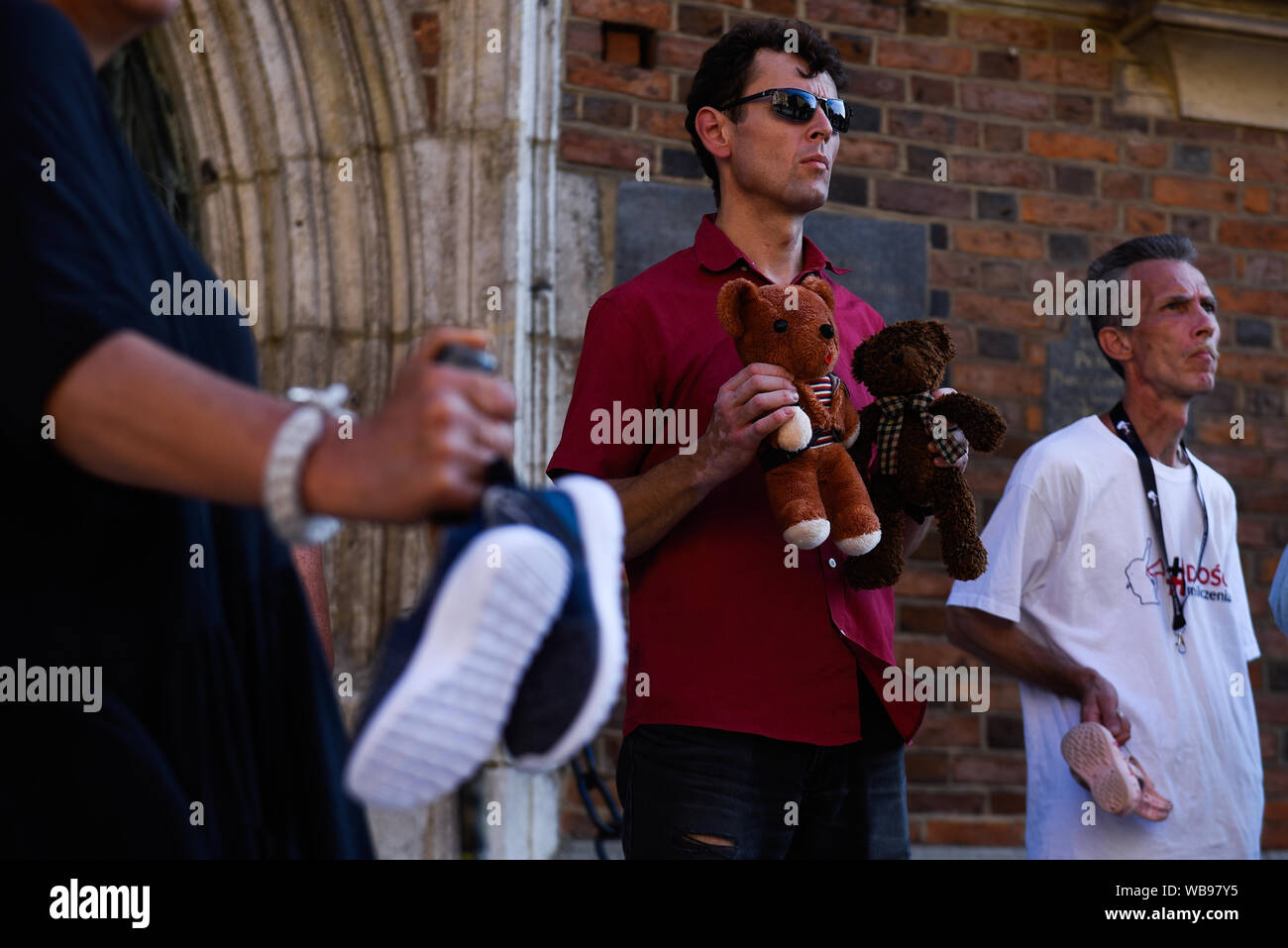 Krakow, Poland. 25th Aug, 2019. A woman holds baby shoes at the St. Mary's Basilica during the commemoration.Baby shoes remembrance is an international symbolic commemoration for children who were victims of pedophile priests. The Baby Shoes Remembrance campaign was born in Ireland and involves hanging children's shoes with black ribbons on church fences. Credit: SOPA Images Limited/Alamy Live News Stock Photo