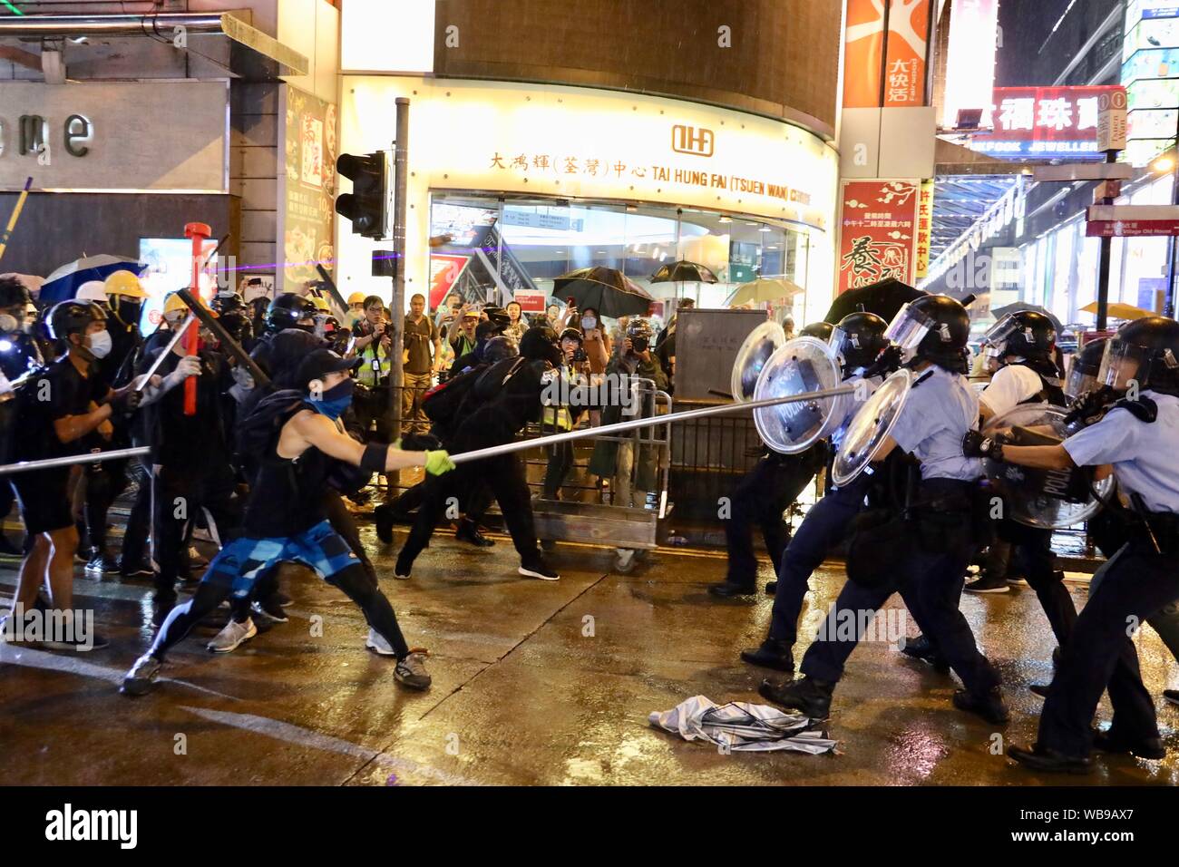 Hong Kong, New Territories of south China's Hong Kong. 25th Aug, 2019. Radical protesters attack police officers in Tsuen Wan, in the western New Territories of south China's Hong Kong, Aug. 25, 2019. Radical protesters block various roads, hurl bricks and stones at police officers in the protest. Credit: Lui Siu Wai/Xinhua/Alamy Live News Stock Photo