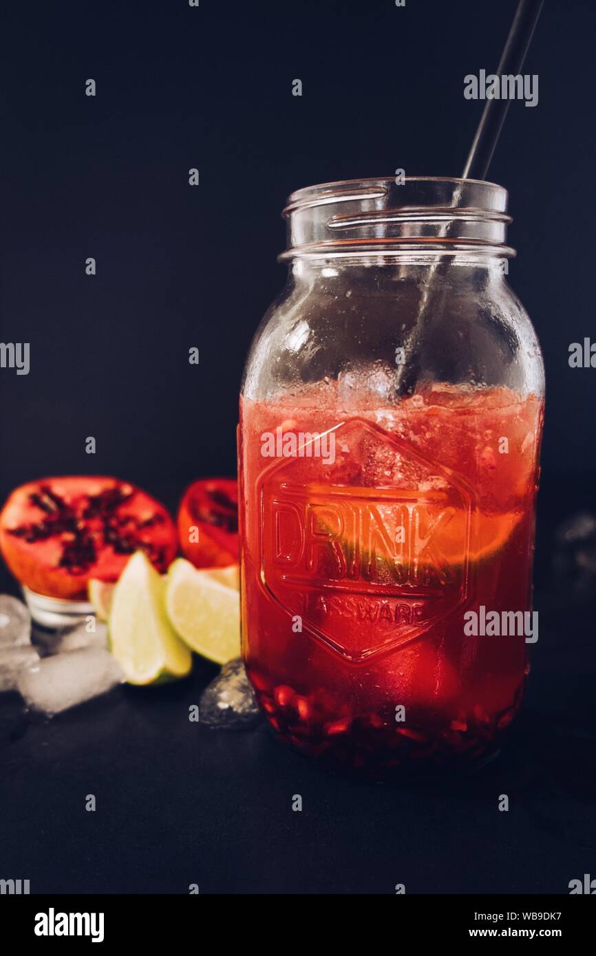 https://c8.alamy.com/comp/WB9DK7/vertical-shot-of-a-glass-jar-cup-filled-with-pomegranate-juice-with-a-straw-on-a-black-background-WB9DK7.jpg