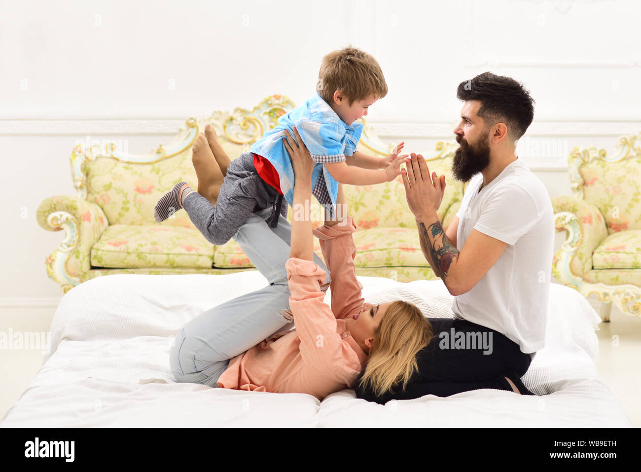 Mother And Father Cuddling With Cute Son Young Family Spend