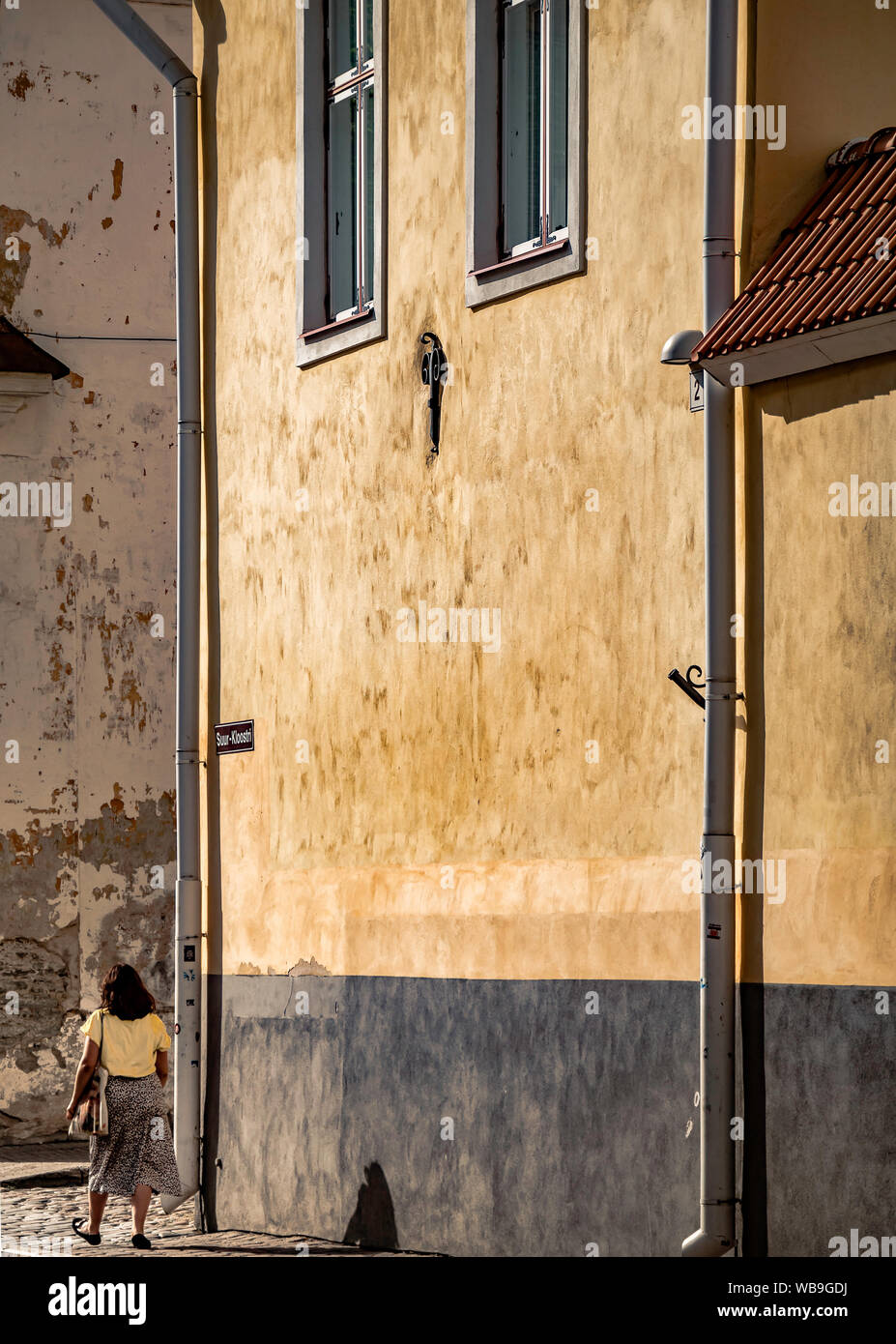 Tallinn, Estonia. Aug 13, 2019: Woman with matching colors walking in beautiful Old Town of Tallinn, Estonia Stock Photo