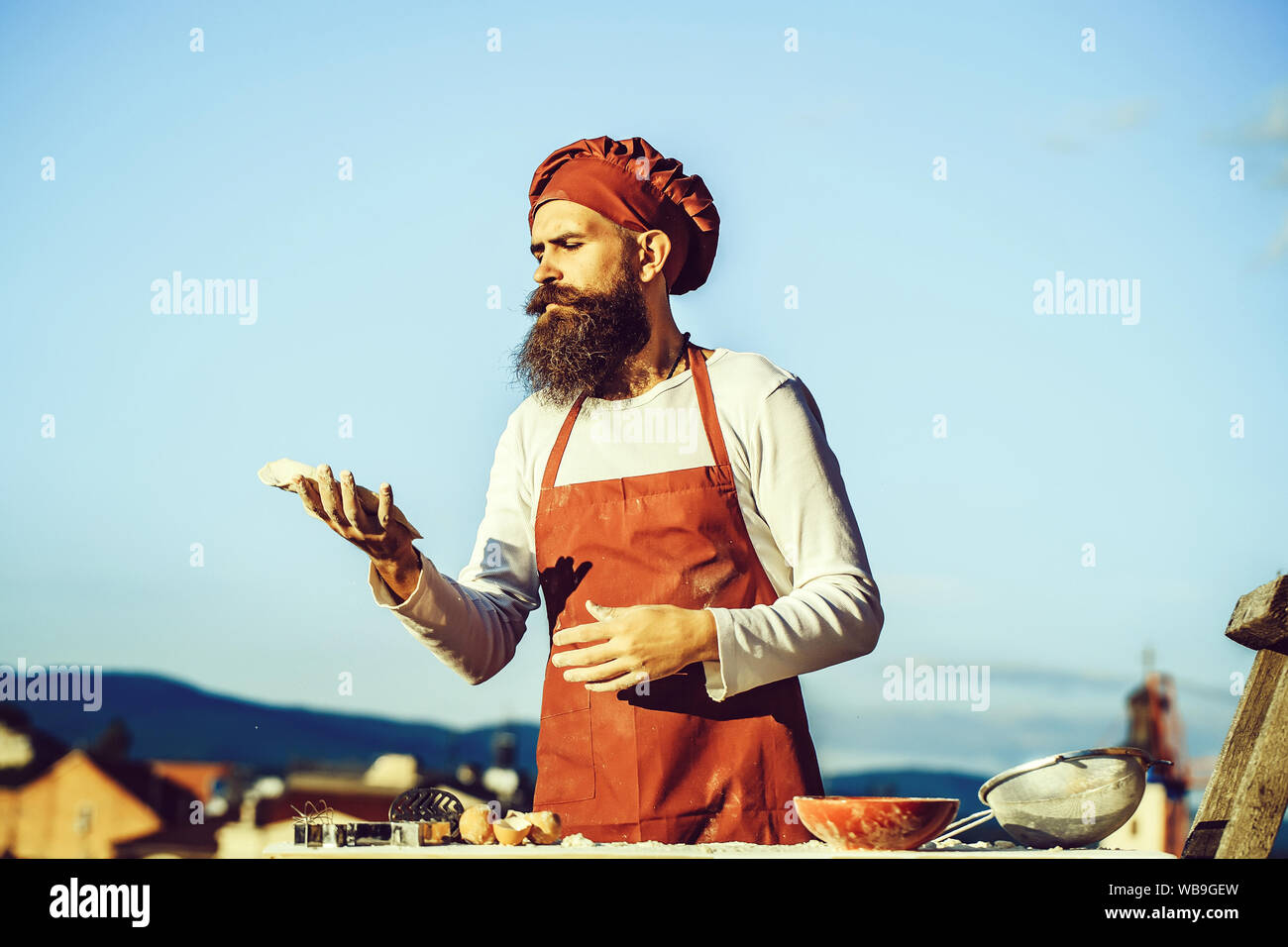 Handsome bearded man cook chef in uniform and red hat with long beard ...