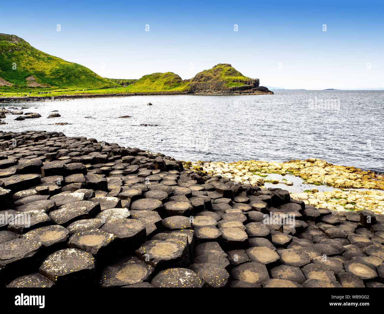 Giant’s Causeway, Northern Ireland, UK. Unique hexagonal and pentagonal geological formations of volcanic basalt rocks at the Atlantic coast, partly c Stock Photo