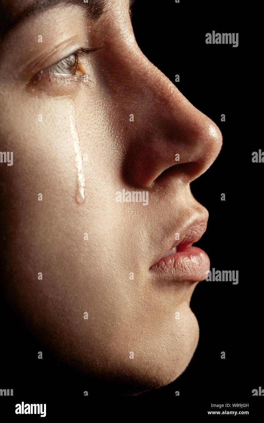 sad woman crying, looking aside on black background, closeup portrait,  profile view Stock Photo - Alamy