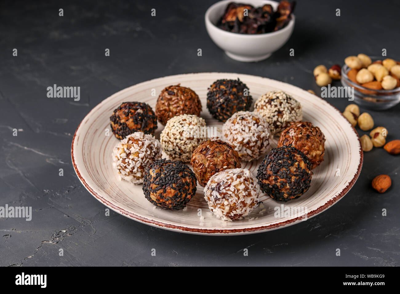 Energy balls of nuts, oatmeals and dried fruit in plate on dark