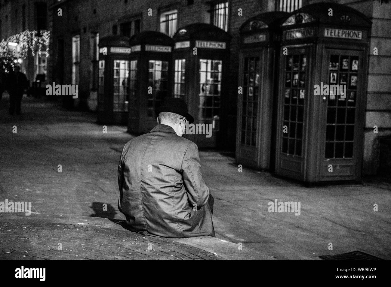 Old man reading book in London at night Stock Photo