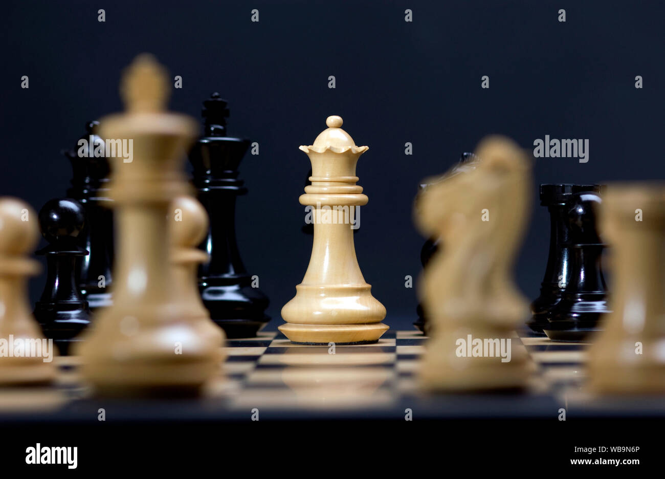 Chess board with focus on the white queen. Stock Photo