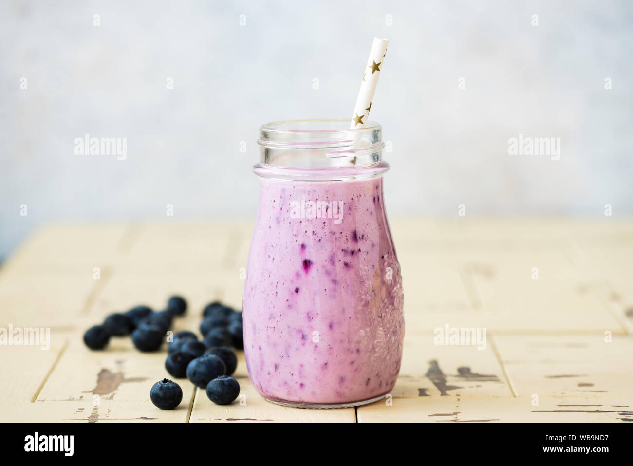 Blended blueberry smoothie in glass with a drinking straw. Healthy refreshing vitamin drink Stock Photo