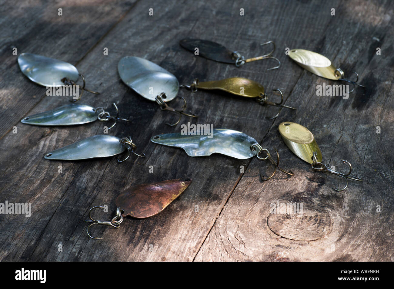 https://c8.alamy.com/comp/WB9NRH/metal-spinners-in-the-shape-of-a-spoon-of-different-colors-for-catching-a-predator-on-a-vintage-wooden-background-the-concept-of-choosing-bait-for-di-WB9NRH.jpg