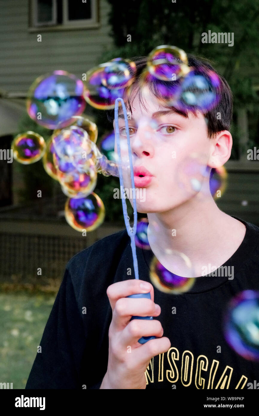 Teenage Boy Blowing Soap Bubbles Stock Photo Alamy