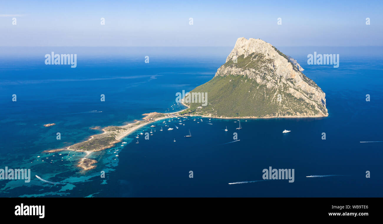 View from above, stunning aerial view of the beautiful Tavolara Island with its beach bathed by a turquoise clear sea. Stock Photo