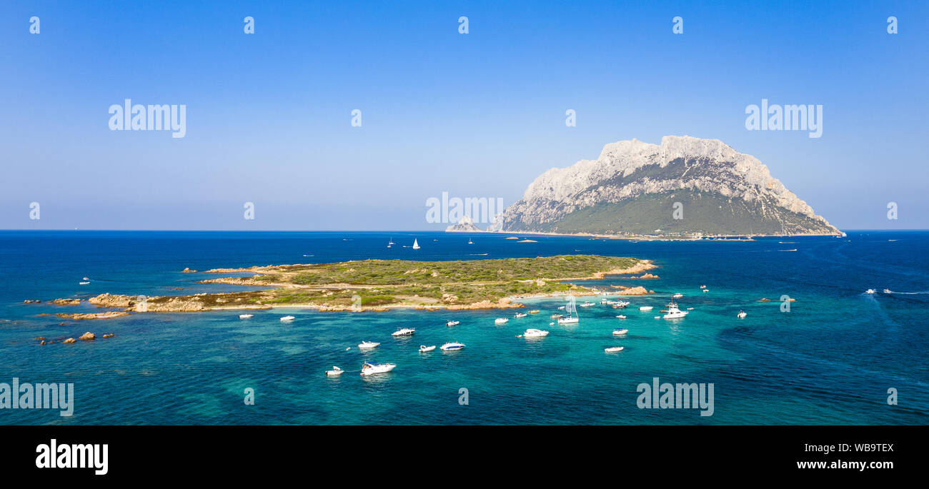View from above, stunning aerial view of the beautiful Tavolara Island with its beach bathed by a turquoise clear sea. Stock Photo