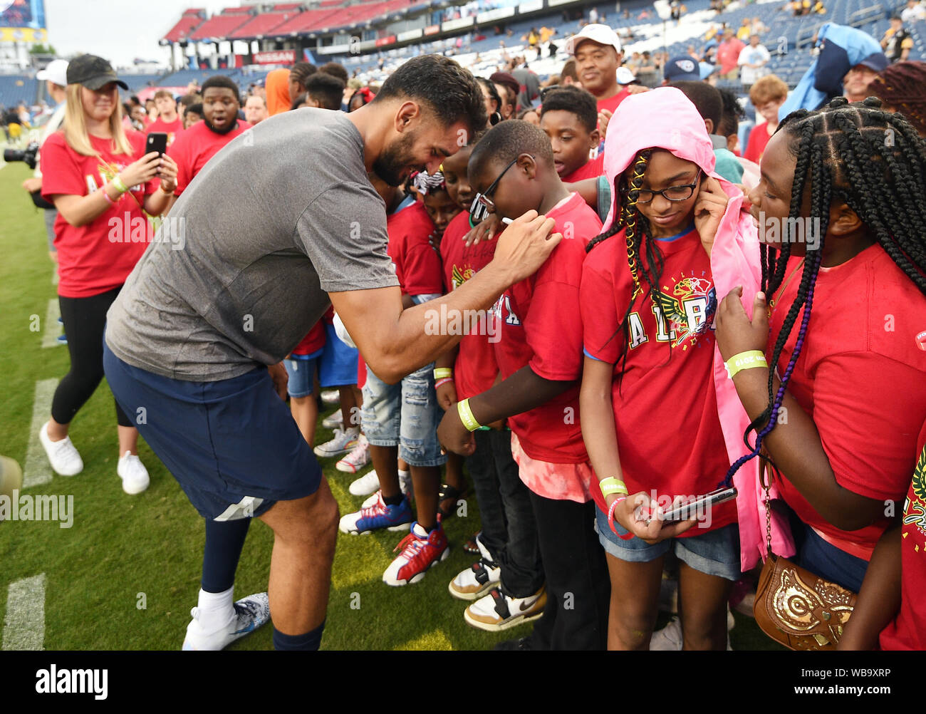 Nashville, Tennessee, USA. 25th Aug 2019. Tennessee Titans quarterback Marcus Mariota (8) signs a shirt of fans from Nashville Boys and Girls Club and Tennessee Special Olympics during an NFL game between the Pittsburg Steelers and the Tennessee Titans at Nissan Stadium in Nashville TN. (Mandatory Photo Credit: Steve Roberts/CSM) Credit: Cal Sport Media/Alamy Live News Stock Photo