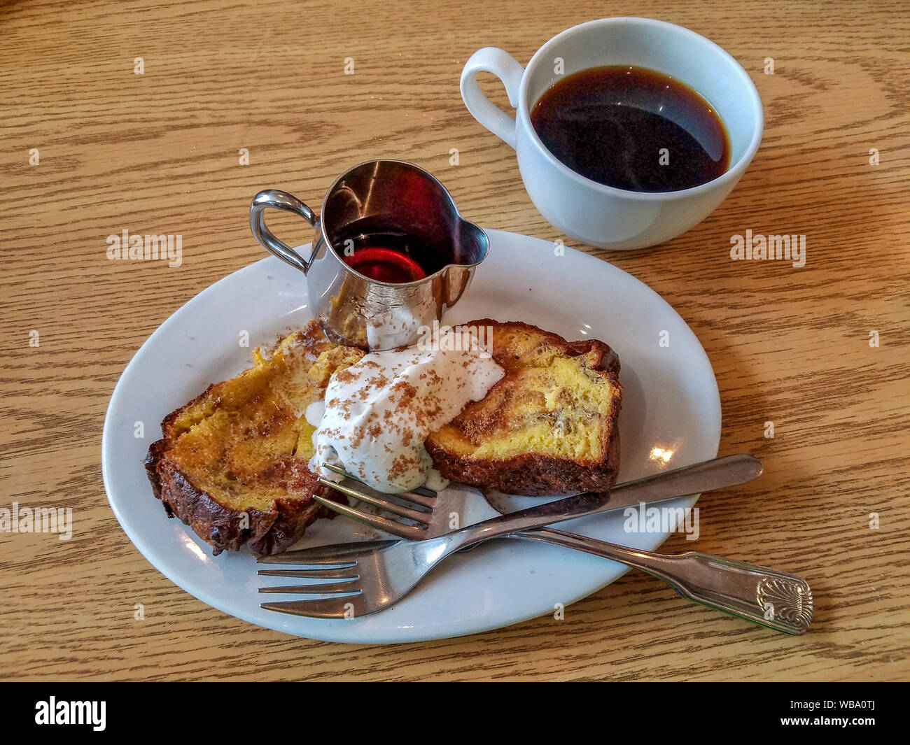 French toast with cinnamon whipped cream and syrup at Cosmos Bistro, a downtown cafe serving comfort food with flair. Stock Photo