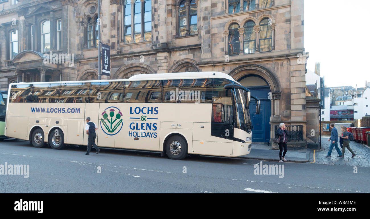 A Lochs and Glens Holidays coach parked outside Minto House, Chambers Street in central Edinburgh, Scotland, UK Stock Photo