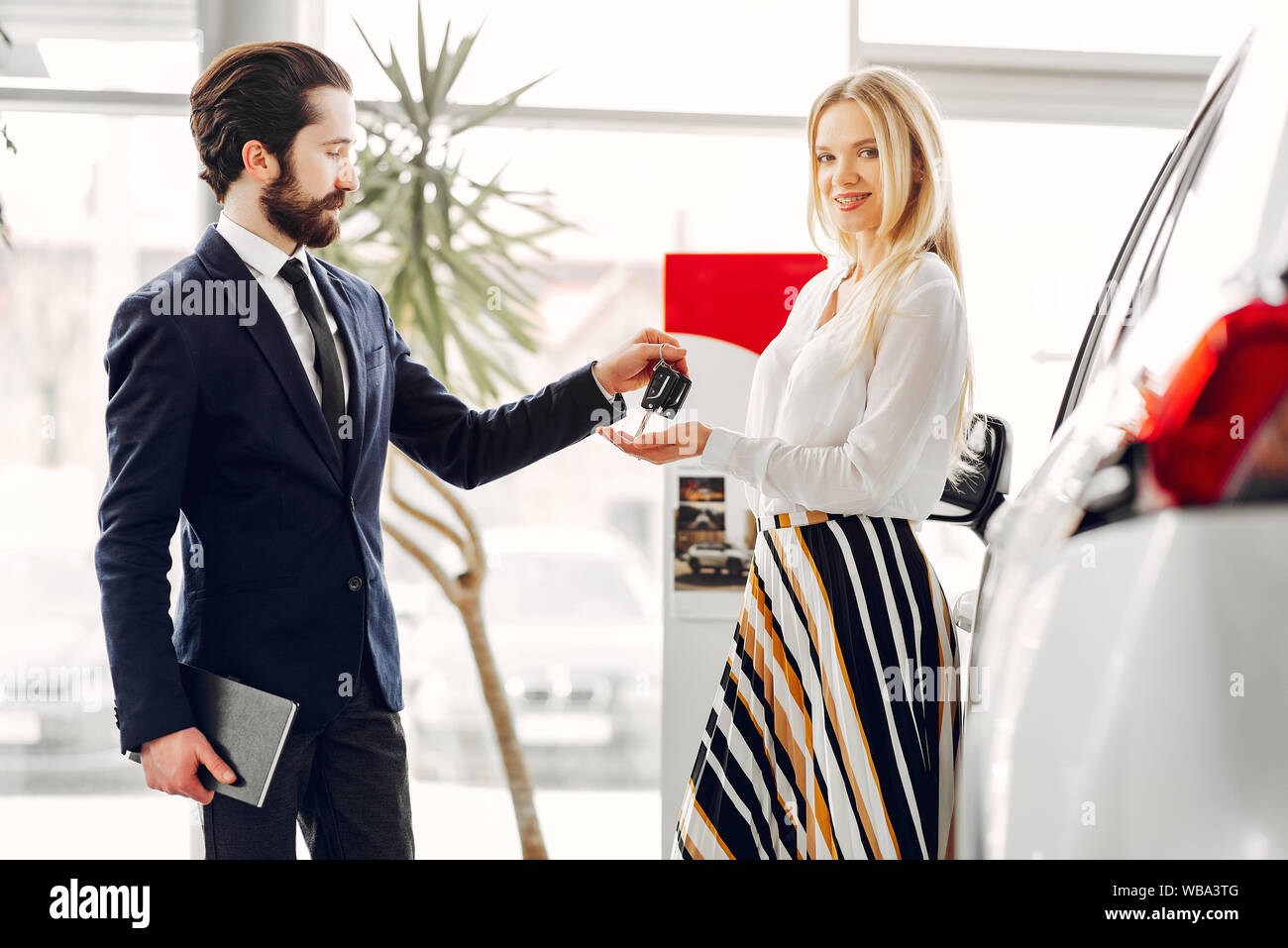 Woman buying the car. Lady in a car salon. Manager with a client Stock