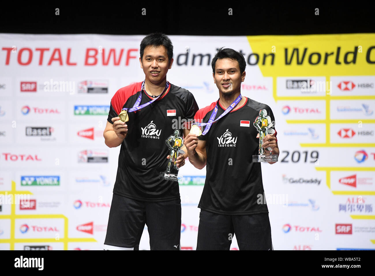 Basel, Switzerland. 25th Aug, 2019. Gold medalists Mohammad Ahsan(R)/Hendra  Setiawan of Indonesia pose for photos during the awarding ceremony of the  men's doubles final at the BWF Badminton World Championships 2019 in