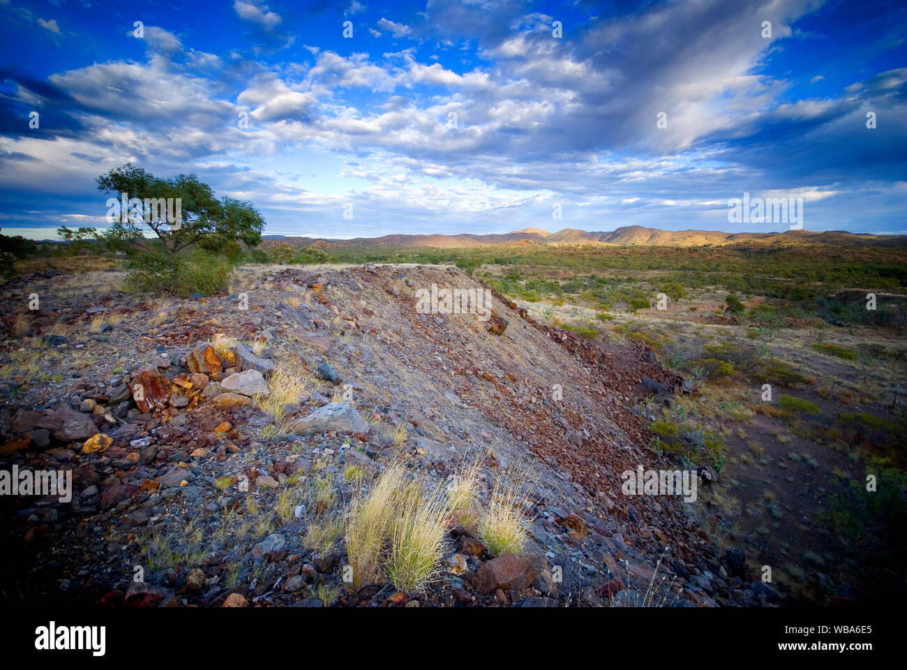 Piles of overburden at abandoned Mary Kathleen uranium mine, closed in 1982.  The land has been rehabilitated.  Selwyn Range between Mount Isa and Clo Stock Photo