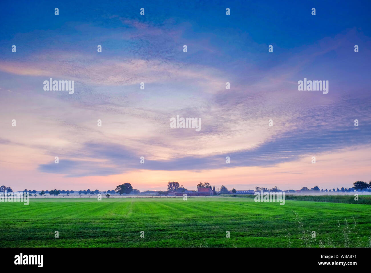 Colorful glowing sunrise over a countryside farming area, creating an ...