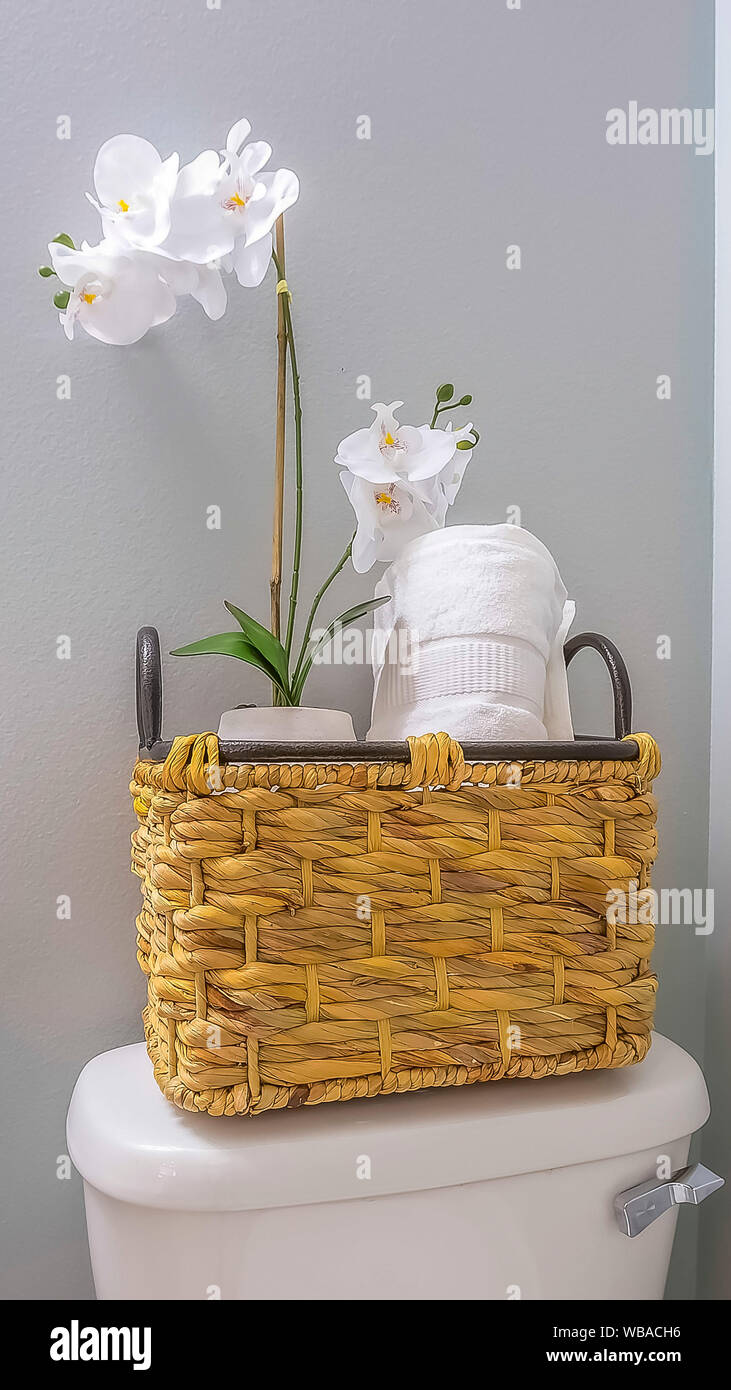 Vertical Woven basket with tissue roll and white flowers placed on top