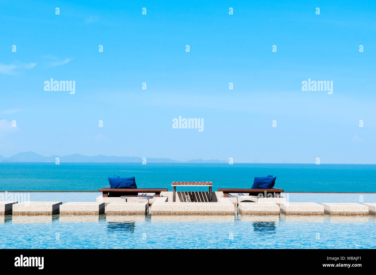 Infinity pool with blue sea and clear sky. Stock Photo