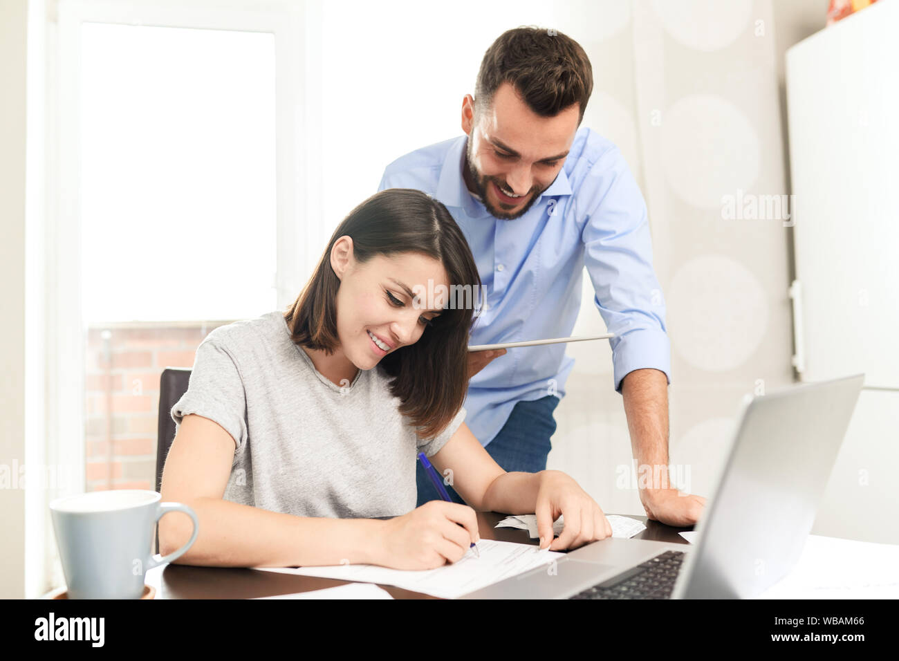 Content confident young man using tablet app while assisting girlfriend Stock Photo